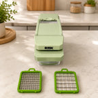 Front view of the RüK food chopper on a kitchen countertop next to two sharp stainless steel dicing blade inserts, designed for effortless meal prep and safe dishwasher cleaning.